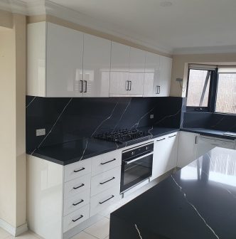 black marble kitchen tops with white cupboards and draws